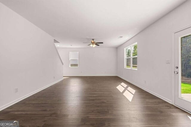 1612 Oakbrook Pond Pl, Dacula, GA 30019 - unfurnished living room with dark wood-style flooring, ceiling fan, and baseboards