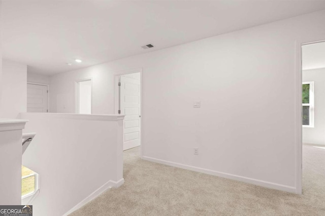 hallway featuring light colored carpet, baseboards, and recessed lighting