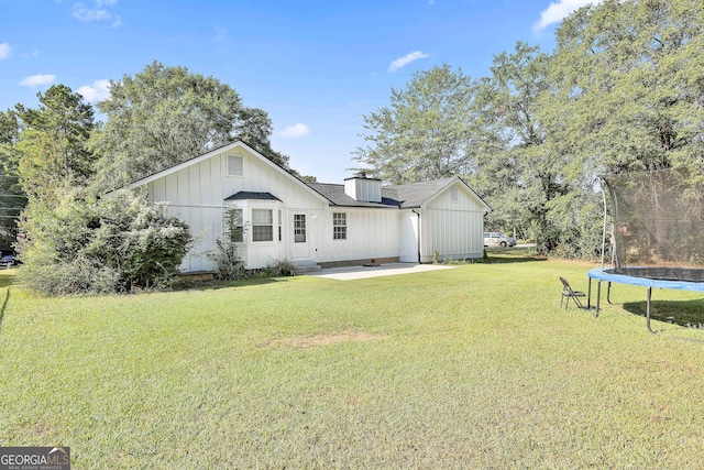 325 Sweetbriar Ln, Griffin, GA 30224 - back of house featuring a yard, entry steps, a patio area, a trampoline, and board and batten siding