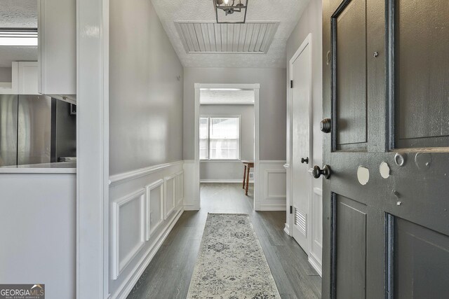325 Sweetbriar Ln, Griffin, GA 30224 - foyer with dark wood-style flooring, wainscoting, a textured ceiling, and visible vents