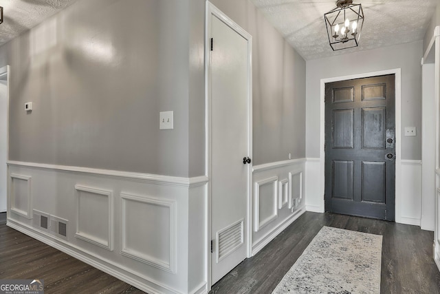 325 Sweetbriar Ln, Griffin, GA 30224 - entrance foyer with dark wood-type flooring, a decorative wall, a notable chandelier, and visible vents