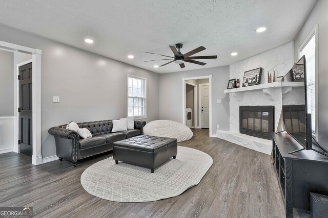 325 Sweetbriar Ln, Griffin, GA 30224 - living room featuring ceiling fan, a textured ceiling, a fireplace, and dark wood finished floors