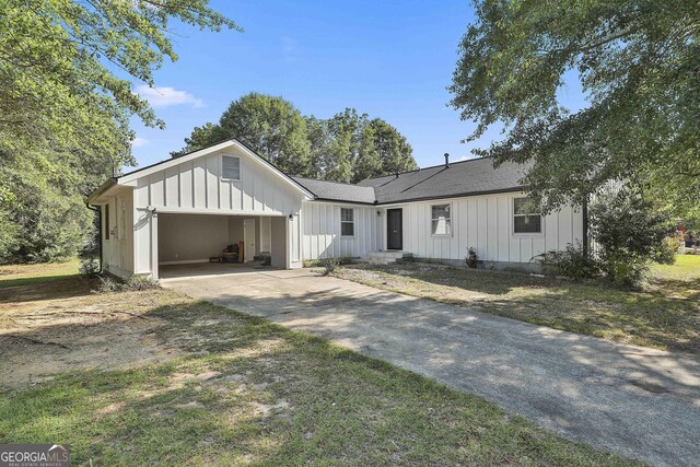 325 Sweetbriar Ln, Griffin, GA 30224 - view of front facade with a shingled roof, driveway, board and batten siding, and an attached garage