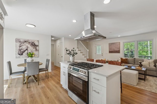 388 Pine Trl, Canton, GA 30115 - kitchen with light wood-type flooring, white cabinetry, exhaust hood, a kitchen island, and stainless steel range with gas cooktop
