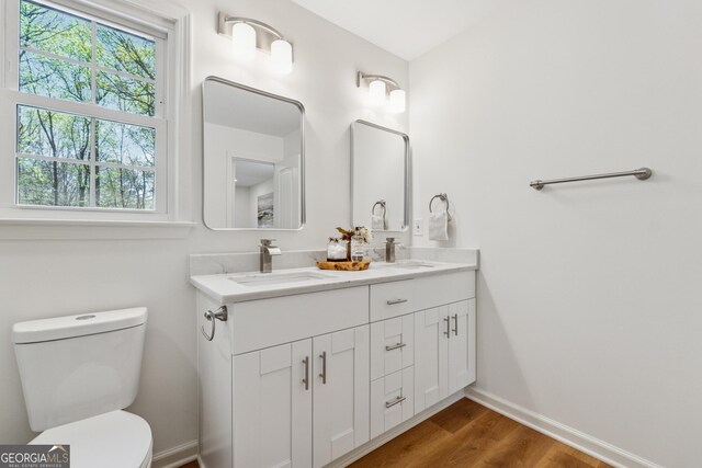 388 Pine Trl, Canton, GA 30115 - bathroom featuring toilet, wood finished floors, double vanity, and a sink