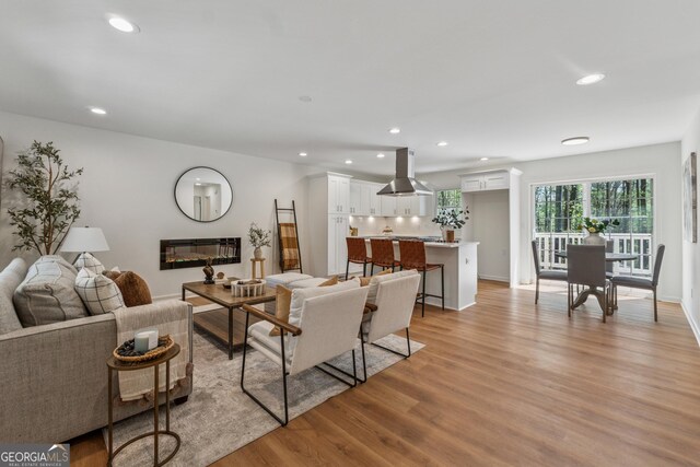 388 Pine Trl, Canton, GA 30115 - living area with light wood-style floors, baseboards, a glass covered fireplace, and recessed lighting
