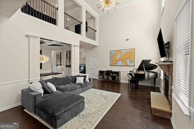 living area with visible vents, baseboards, ornamental molding, and wood finished floors