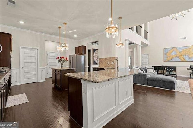 kitchen featuring dark wood-style flooring, an inviting chandelier, stainless steel fridge, crown molding, and visible vents