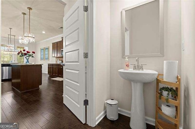 bathroom with a sink, baseboards, a notable chandelier, and wood finished floors