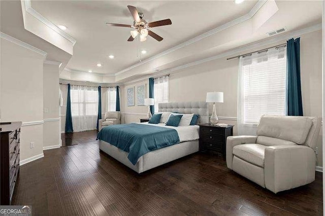 bedroom featuring baseboards, crown molding, dark wood-type flooring, visible vents, and a tray ceiling