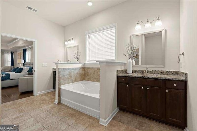 bathroom featuring a garden tub, vanity, visible vents, and a wealth of natural light