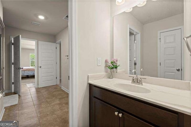 ensuite bathroom with vanity, baseboards, tile patterned floors, connected bathroom, and visible vents