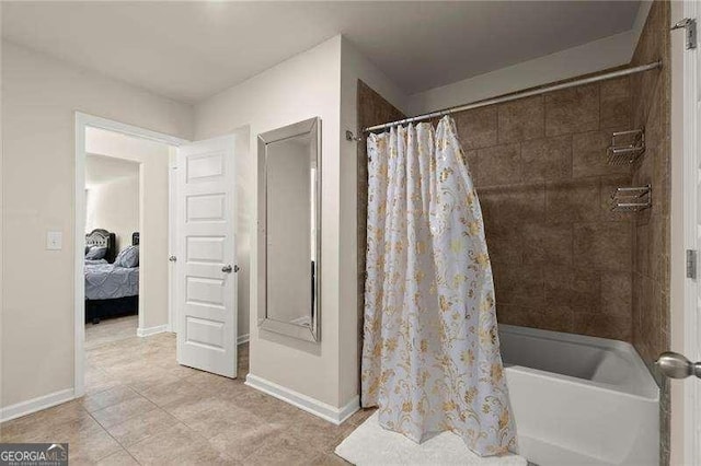 full bathroom with shower / bath combo with shower curtain, baseboards, ensuite bathroom, and tile patterned flooring