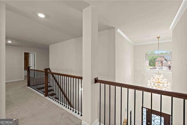 corridor featuring baseboards, ornamental molding, an upstairs landing, carpet, and recessed lighting