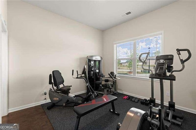 workout area with wood finished floors, baseboards, and visible vents