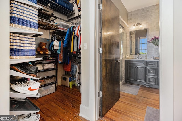 full bath featuring vanity, hardwood / wood-style flooring, and a spacious closet
