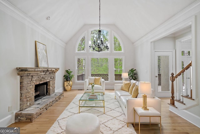 living room with a fireplace, stairway, a chandelier, wood finished floors, and lofted ceiling