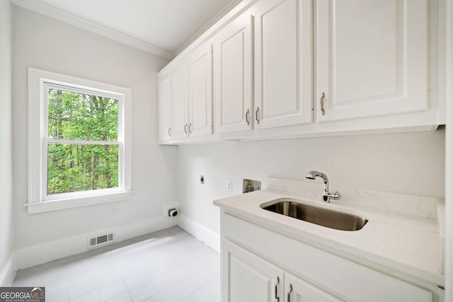 laundry area featuring baseboards, a sink, hookup for an electric dryer, cabinet space, and hookup for a washing machine