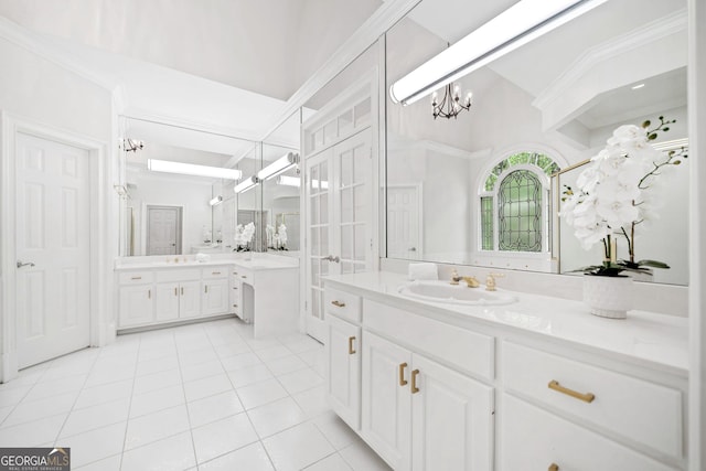 bathroom featuring two vanities, a notable chandelier, tile patterned floors, french doors, and a sink