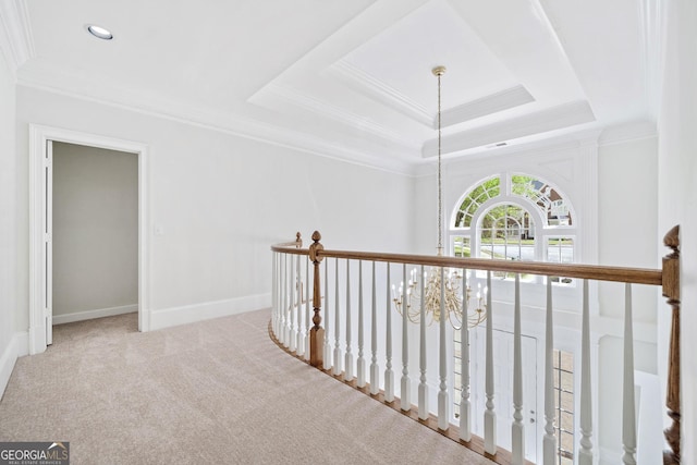 hall featuring crown molding, carpet flooring, and an inviting chandelier