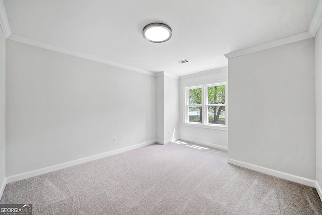 carpeted empty room featuring visible vents, baseboards, and ornamental molding