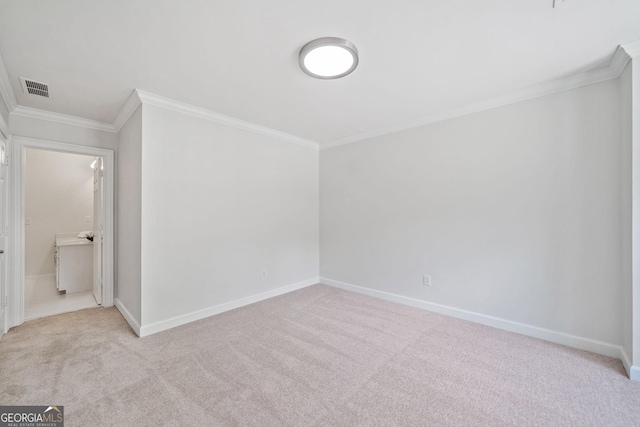 carpeted empty room with visible vents, baseboards, and ornamental molding
