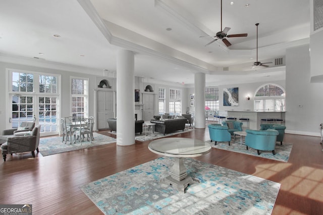 living room with visible vents, a ceiling fan, crown molding, and wood finished floors