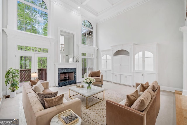 living area with crown molding, light tile patterned floors, a fireplace, a high ceiling, and baseboards