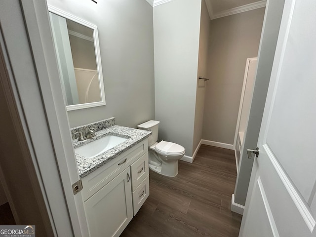 16 Pear St, Ludowici, GA 31316 - full bath featuring baseboards, ornamental molding, toilet, vanity, and wood finished floors