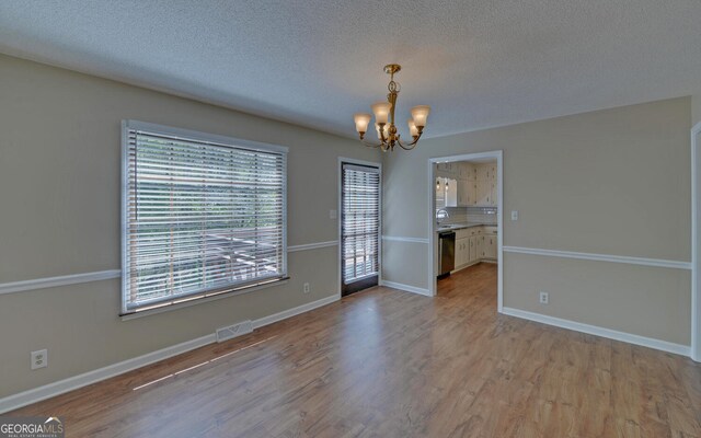 186 Foxdale Dr, Toccoa, GA 30577 - unfurnished dining area featuring plenty of natural light, a notable chandelier, wood finished floors, and visible vents