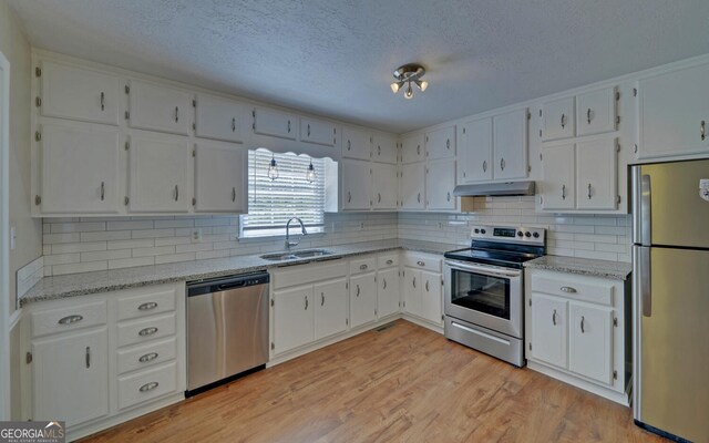 186 Foxdale Dr, Toccoa, GA 30577 - kitchen featuring white cabinets, a sink, a textured ceiling, stainless steel appliances, and under cabinet range hood