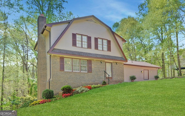 186 Foxdale Dr, Toccoa, GA 30577 - colonial inspired home with brick siding, a chimney, a gambrel roof, and a front yard