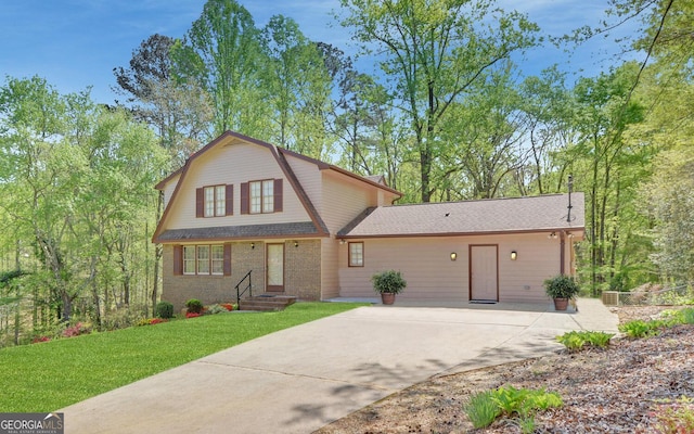 186 Foxdale Dr, Toccoa, GA 30577 - view of front of property with brick siding, a front lawn, concrete driveway, a gambrel roof, and a shingled roof