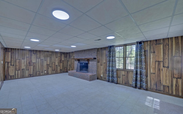 186 Foxdale Dr, Toccoa, GA 30577 - basement featuring a brick fireplace, wood walls, a drop ceiling, and visible vents