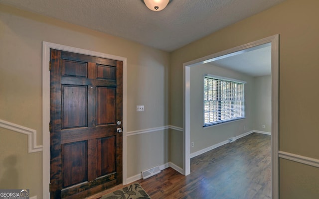 186 Foxdale Dr, Toccoa, GA 30577 - entrance foyer featuring visible vents, a textured ceiling, dark wood-style flooring, and baseboards