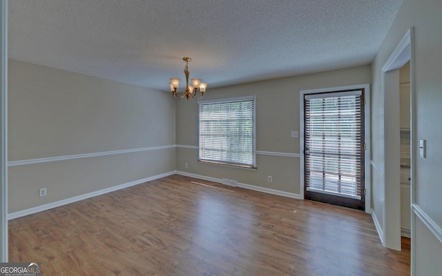 186 Foxdale Dr, Toccoa, GA 30577 - spare room featuring an inviting chandelier, visible vents, wood finished floors, baseboards, and a textured ceiling