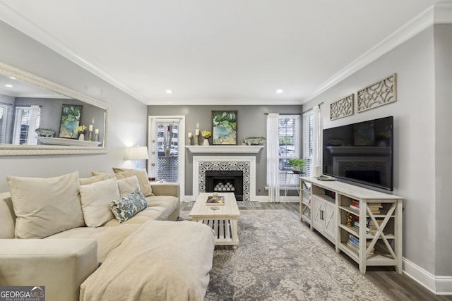 living area with baseboards, a fireplace, crown molding, recessed lighting, and wood finished floors