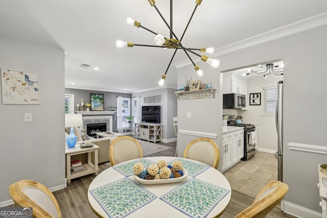 dining room featuring visible vents, baseboards, a notable chandelier, a tiled fireplace, and recessed lighting
