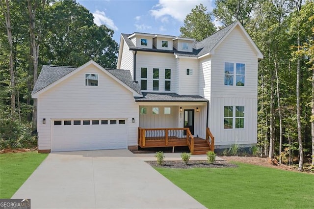view of front of house featuring a porch, a front yard, an attached garage, a shingled roof, and driveway