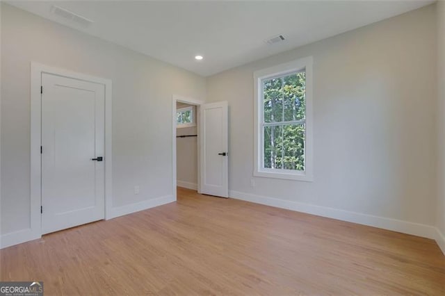 unfurnished bedroom with visible vents, baseboards, and light wood-type flooring
