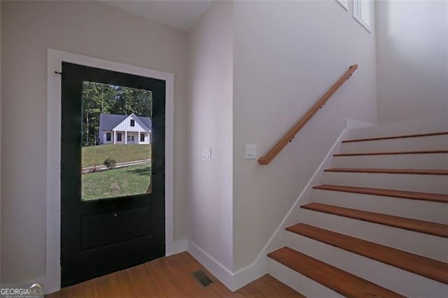 entryway featuring wood finished floors, baseboards, and visible vents