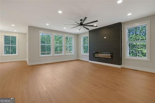 unfurnished living room with baseboards, light wood-style floors, and a fireplace