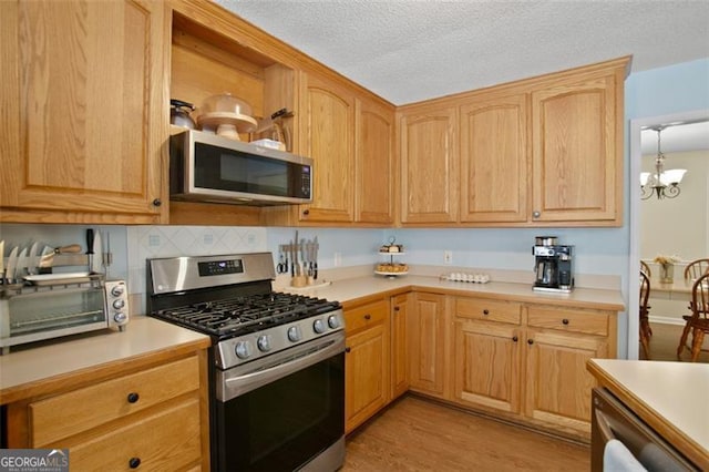 19 Mccrary Ct, Ellijay, GA 30536 - kitchen with light wood-style flooring, light countertops, a textured ceiling, and appliances with stainless steel finishes