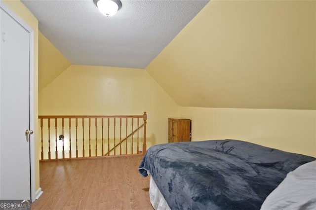 19 Mccrary Ct, Ellijay, GA 30536 - bedroom with vaulted ceiling, wood finished floors, and a textured ceiling