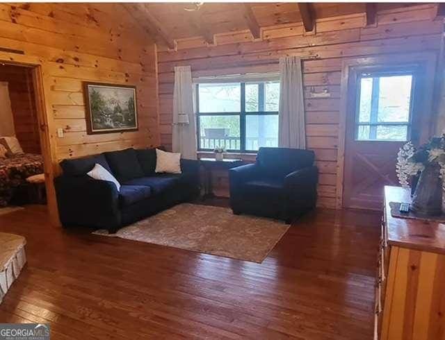 2209 Bell View Ln, Young Harris, GA 30582 - living area with lofted ceiling with beams, wooden walls, wooden ceiling, and wood-type flooring