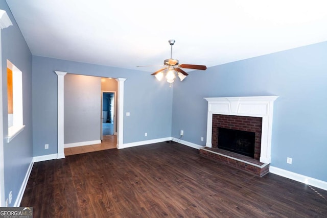 170 Shoal Park Dr, Mcdonough, GA 30252 - unfurnished living room featuring dark wood-style flooring, baseboards, a ceiling fan, and a fireplace
