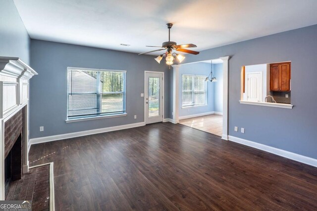 170 Shoal Park Dr, Mcdonough, GA 30252 - unfurnished living room featuring a wealth of natural light, a fireplace with flush hearth, ceiling fan with notable chandelier, and wood finished floors