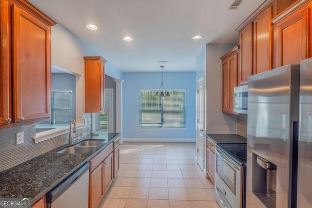 170 Shoal Park Dr, Mcdonough, GA 30252 - kitchen with light tile patterned floors, a sink, brown cabinetry, stainless steel appliances, and backsplash