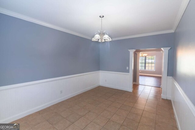 170 Shoal Park Dr, Mcdonough, GA 30252 - empty room featuring ornamental molding, ornate columns, an inviting chandelier, and wainscoting