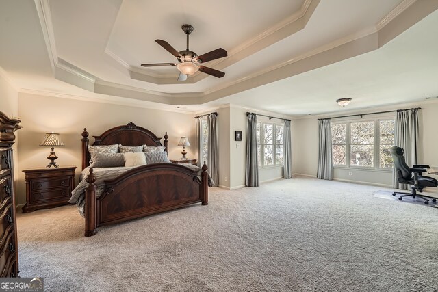 bedroom featuring ornamental molding, a tray ceiling, baseboards, and carpet flooring